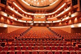 A concert hall with rows of red seats and balconies